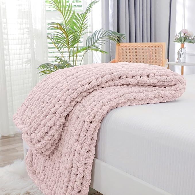 Chunky knit throw blanket, rose tan cable rope pattern, folded on couch