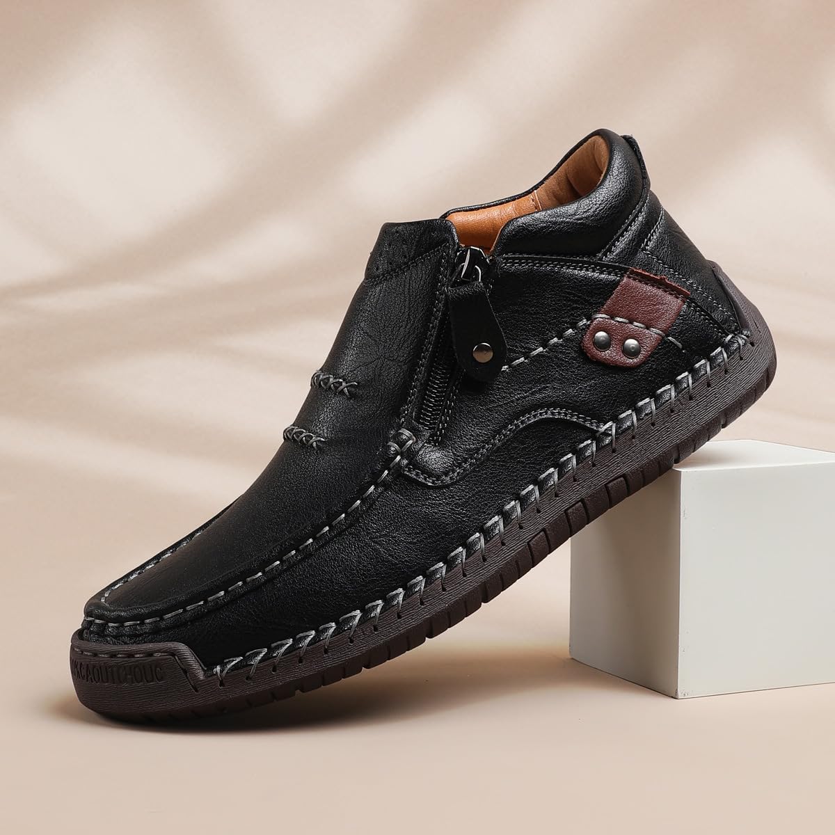 Black leather driving boot with side zipper, stitched vamp, and textured rubber sole