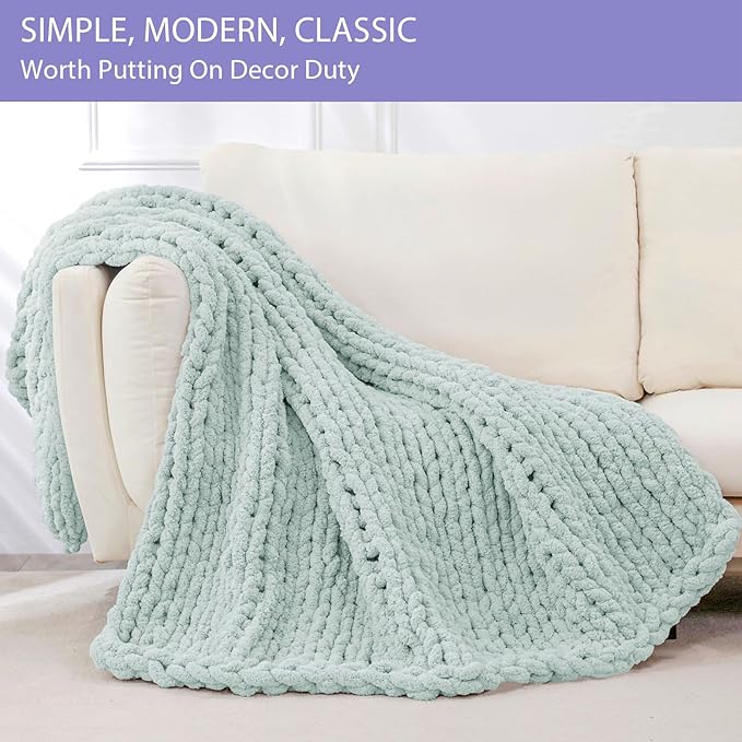Mint chunky knit throw blanket folded over sofa arm, showing rope-cable knit texture.