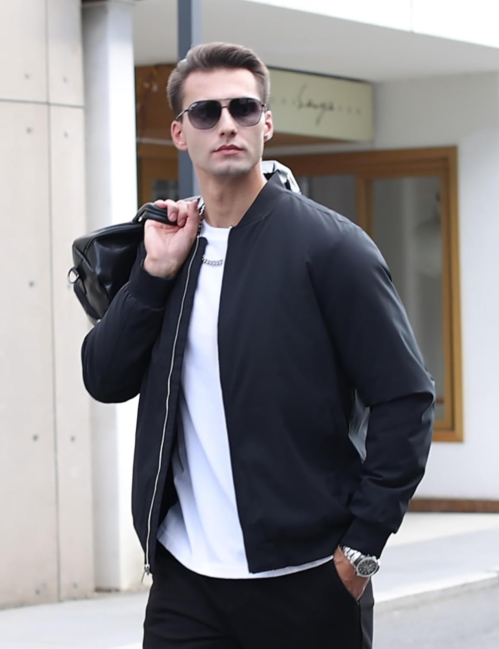 Men's black bomber jacket on model with full-zip front, ribbed cuffs, and pocket details