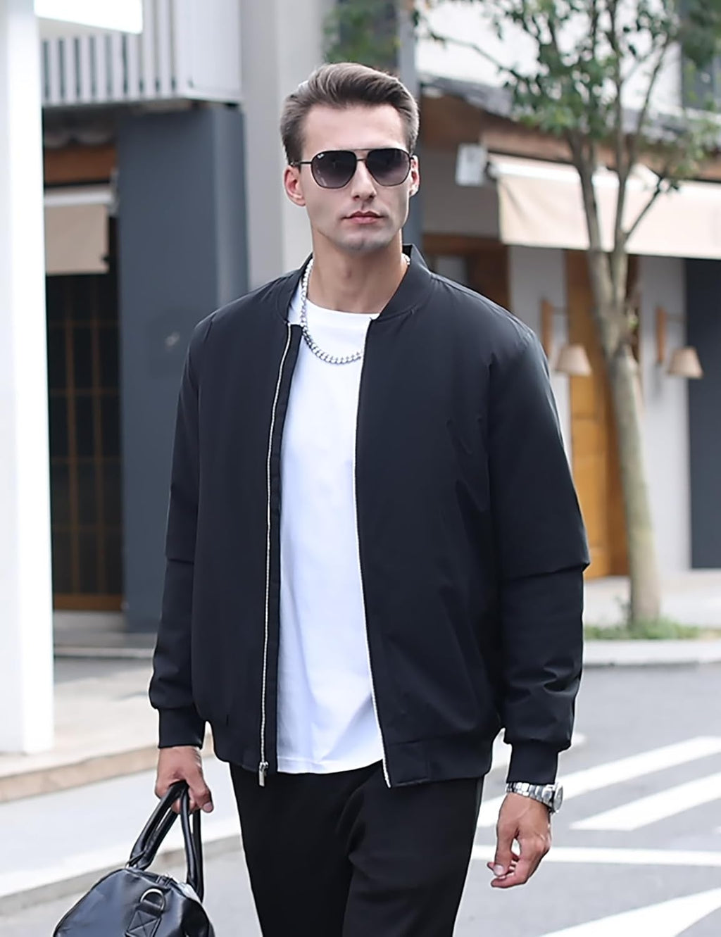 Men's black bomber jacket on model, full-zip front, stand collar, ribbed cuffs