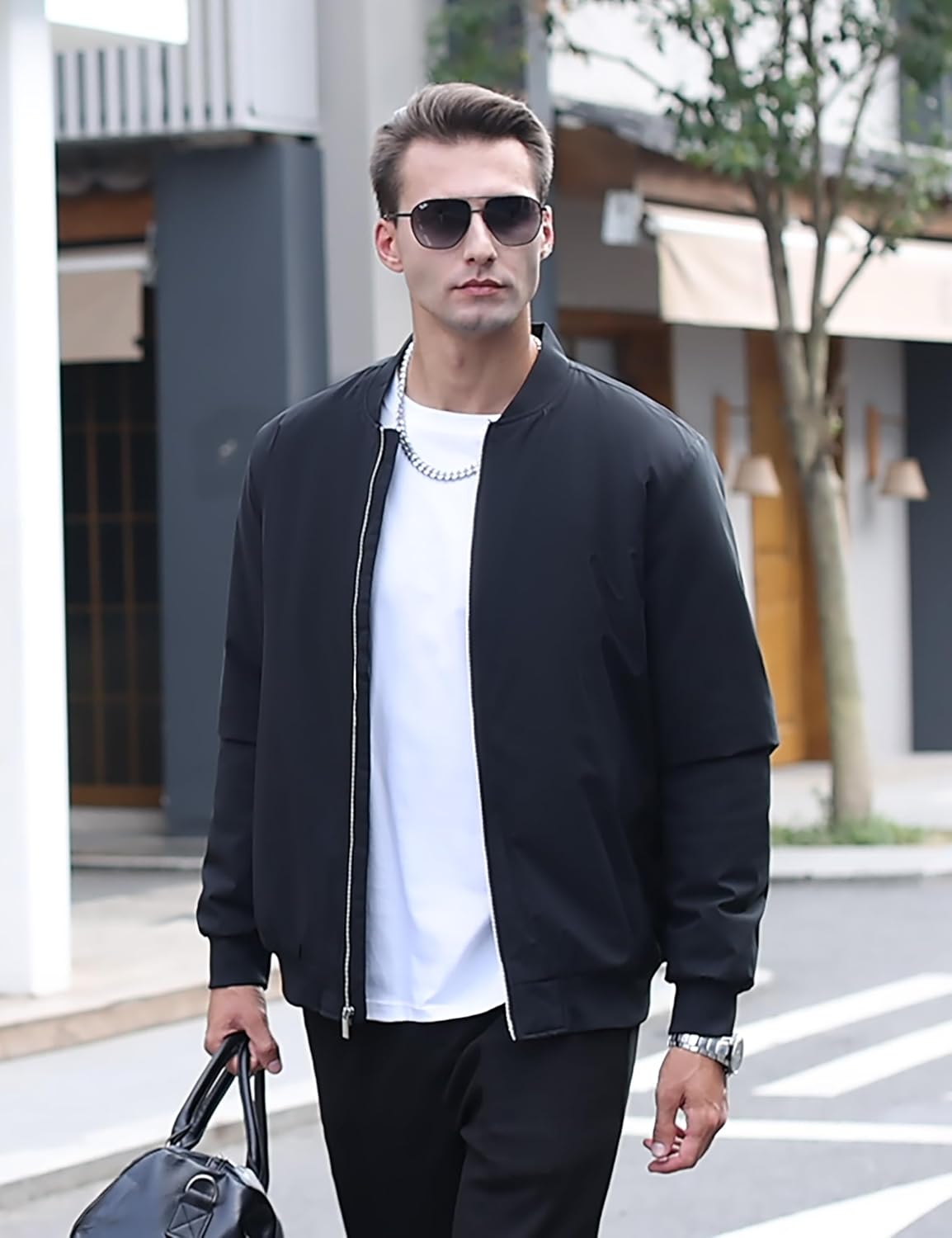 Men's black bomber jacket on model, full-zip front, stand collar, ribbed cuffs