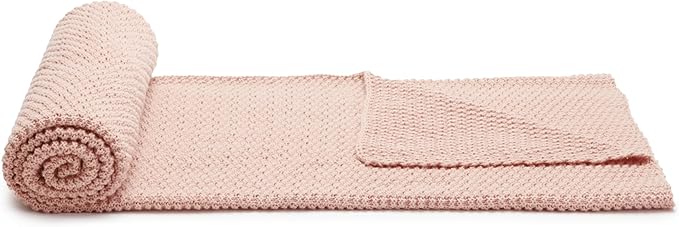 Dusty rose chunky cable knit throw blanket rolled with neat spiral edge