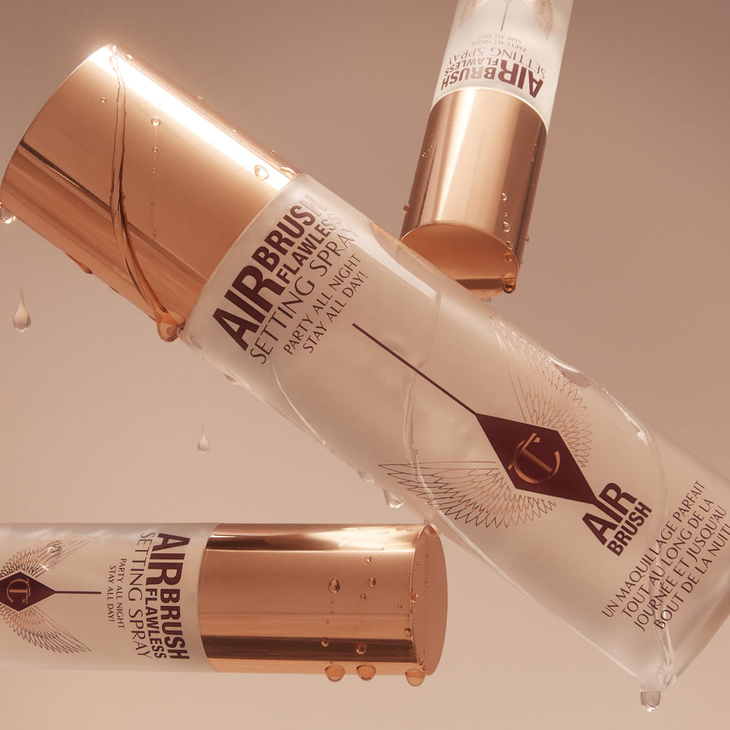 Charlotte Tilbury Airbrush Flawless setting spray bottles with droplets and water splashes