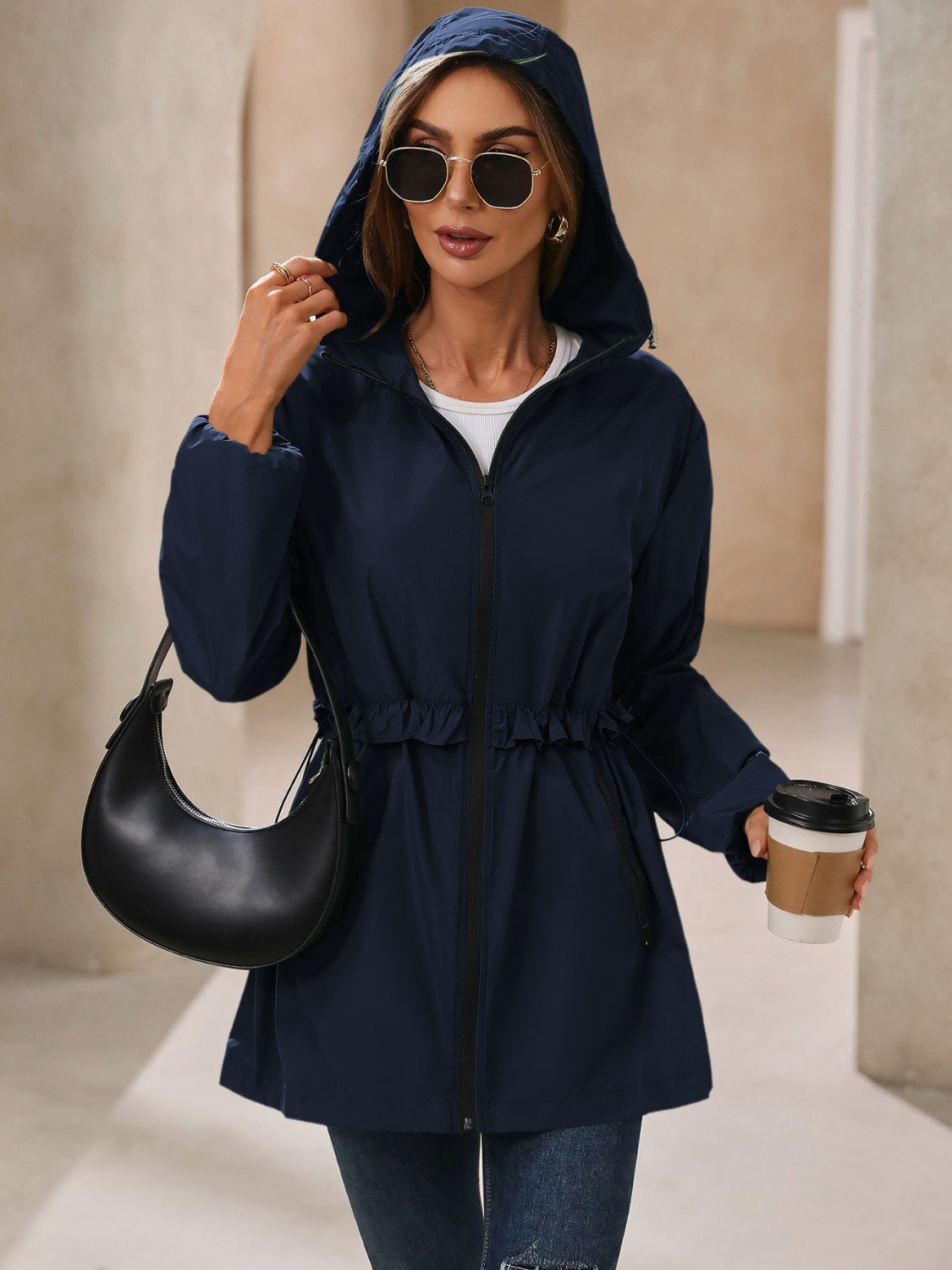 Navy hooded windbreaker jacket with hood up, zip front, and ruffled waist