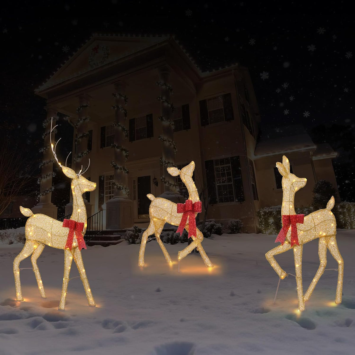 Warm LED-lit gold glitter reindeer family with red bows, outdoor yard display