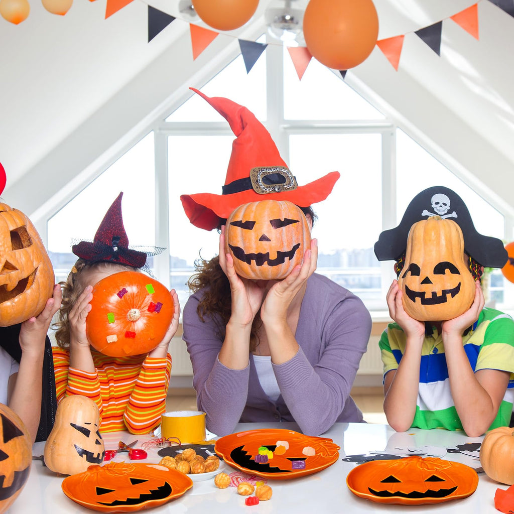 Orange jack-o'-lantern ceramic candy dishes on Halloween party table