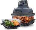 Portable air fryer with dark base and clear glass container filled with chicken pieces