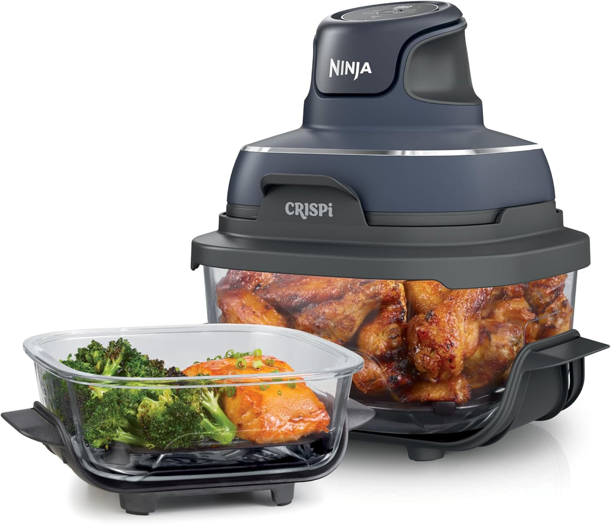 Portable air fryer with dark base and clear glass container filled with chicken pieces