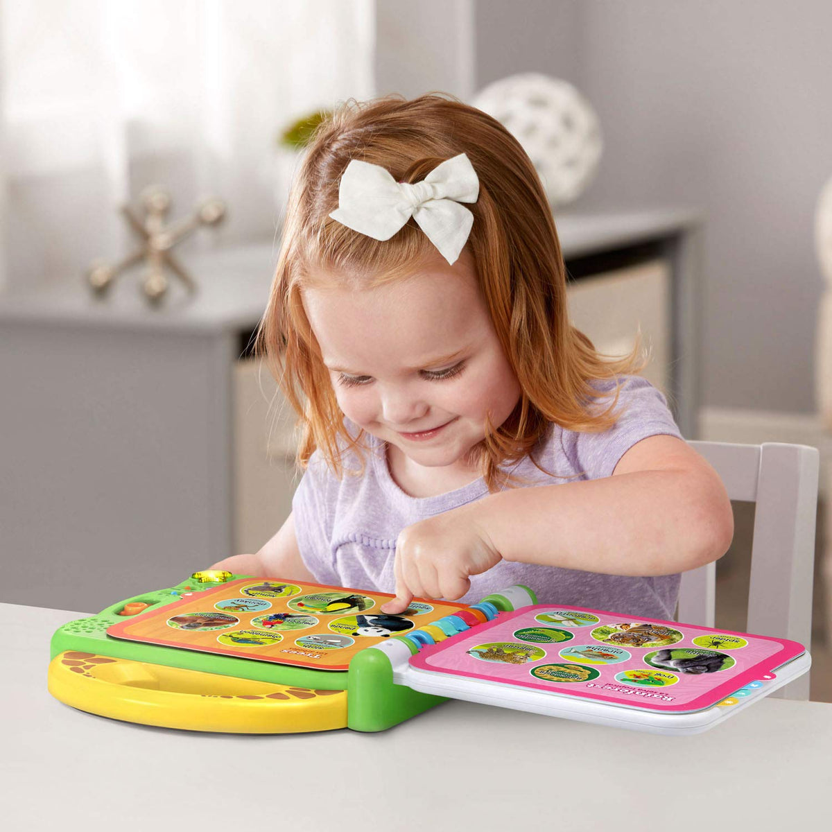Child plays with colorful interactive animal book with two pages open on a table