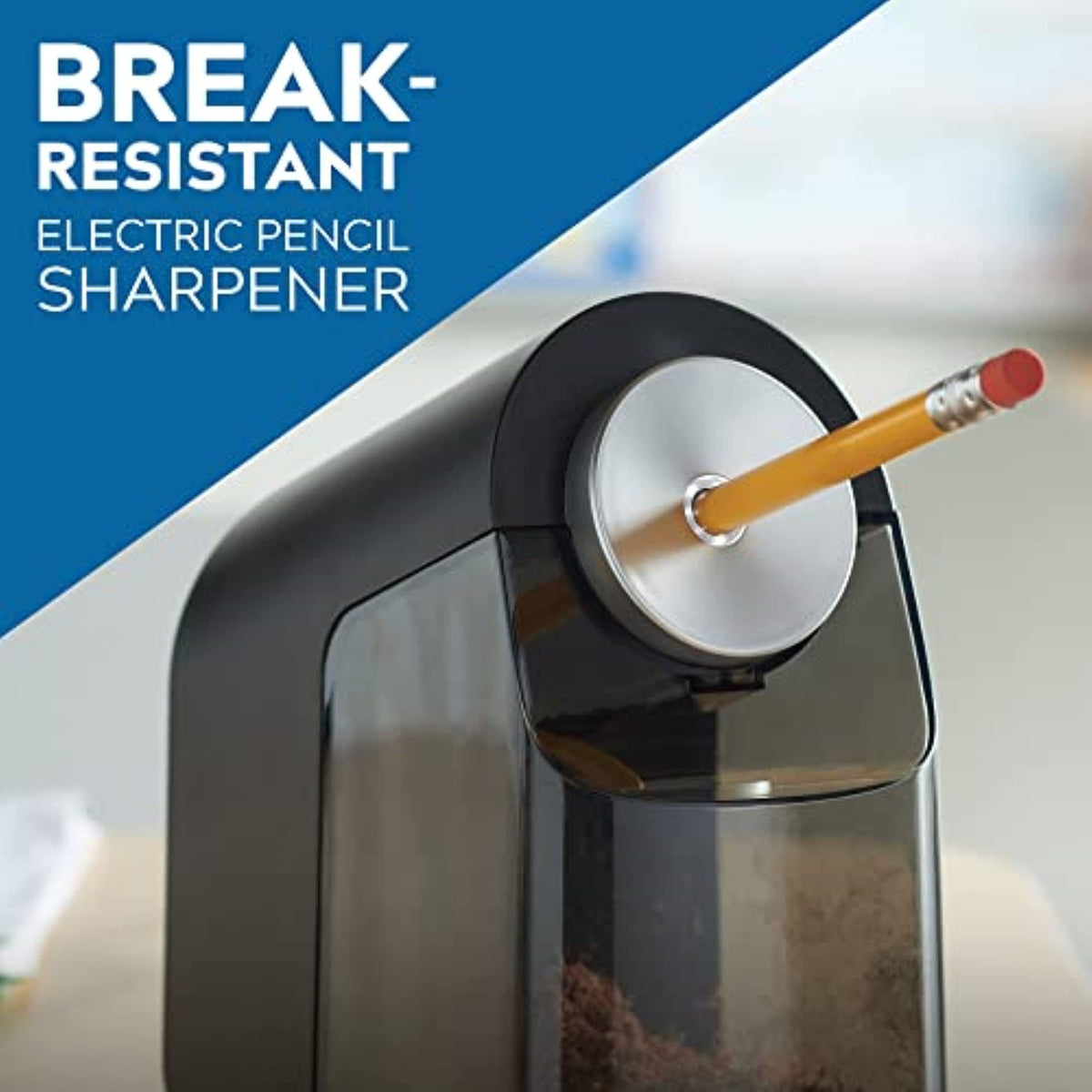 Black electric pencil sharpener with round silver dial and pencil inserted, clear shavings bin.