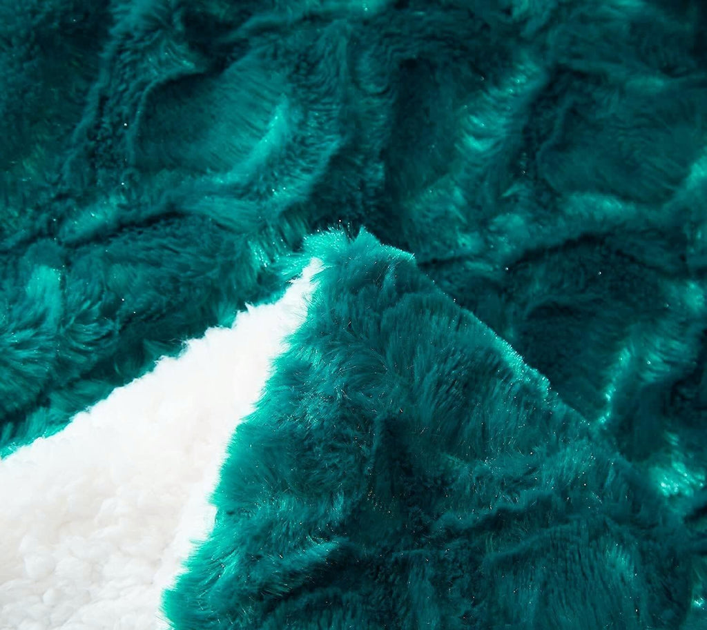 Close-up texture of dark teal faux fur throw with a white sherpa border strip