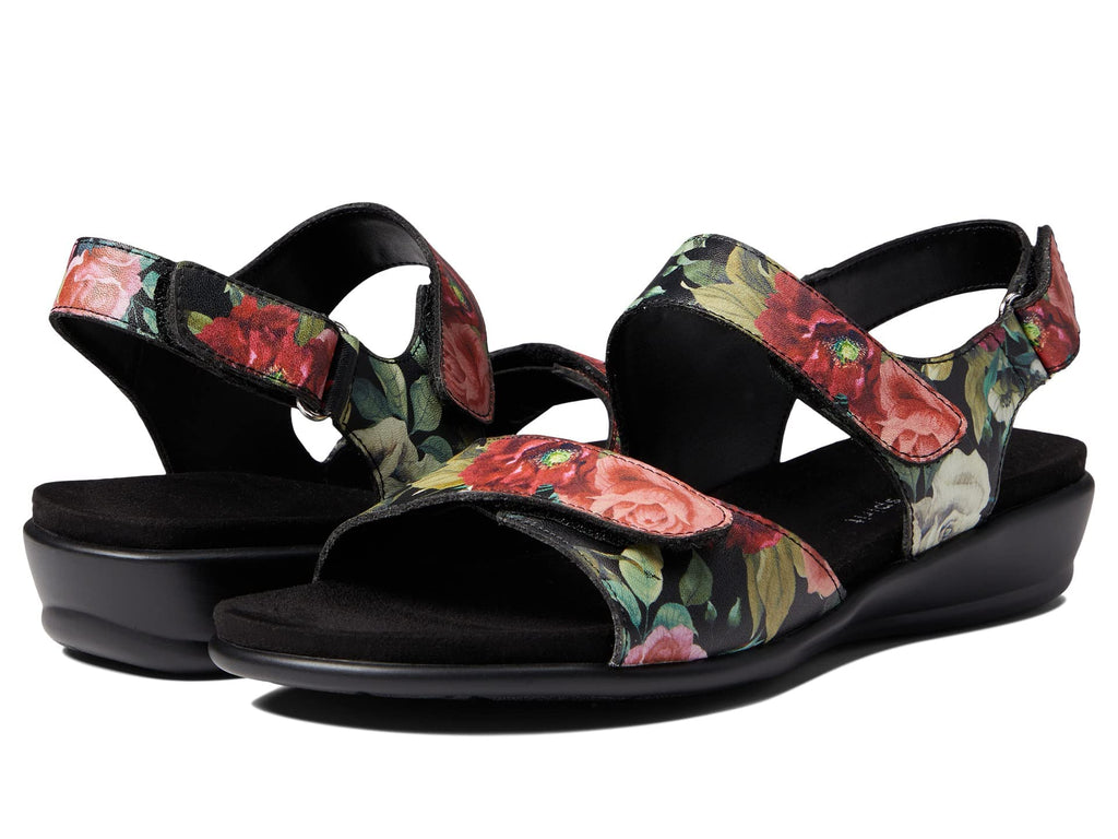 Black wedge sandal with floral upper and open toe, molded sole and slingback strap