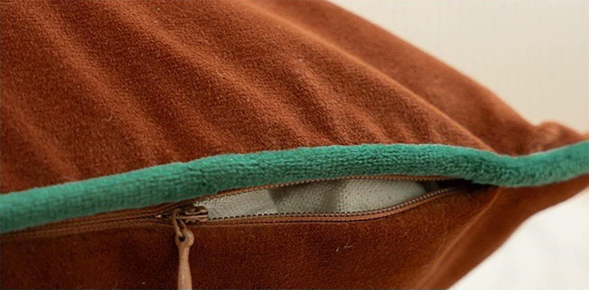 Velvet pillow cover close-up in brown with turquoise edge trim and zipper