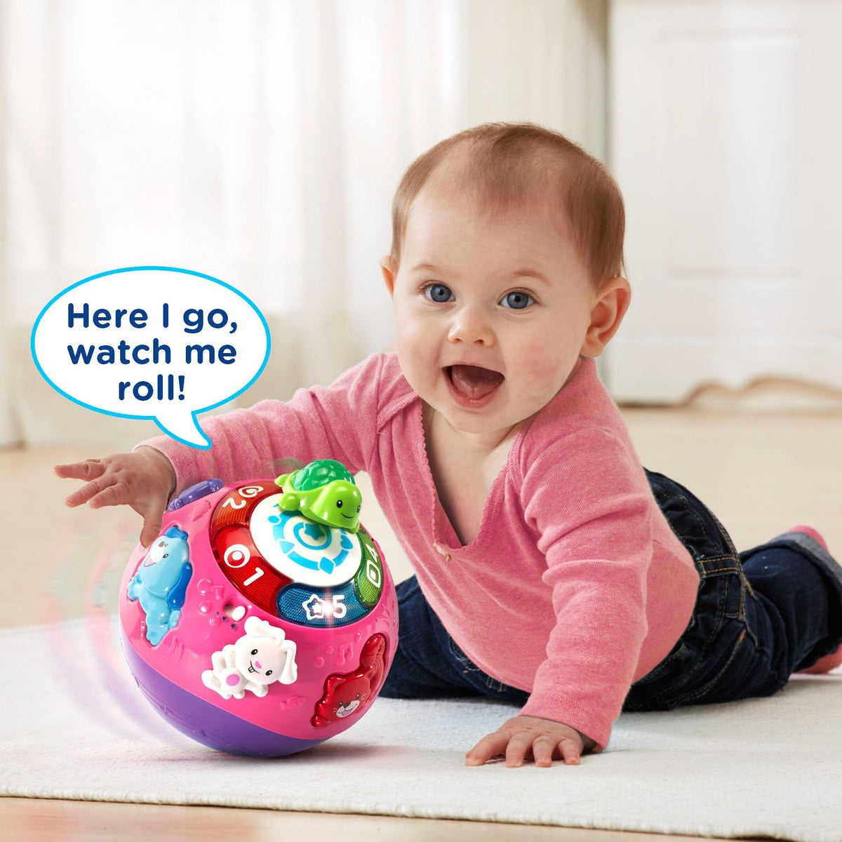 Baby playing with pink and purple rolling ball with green turtle and animal figures