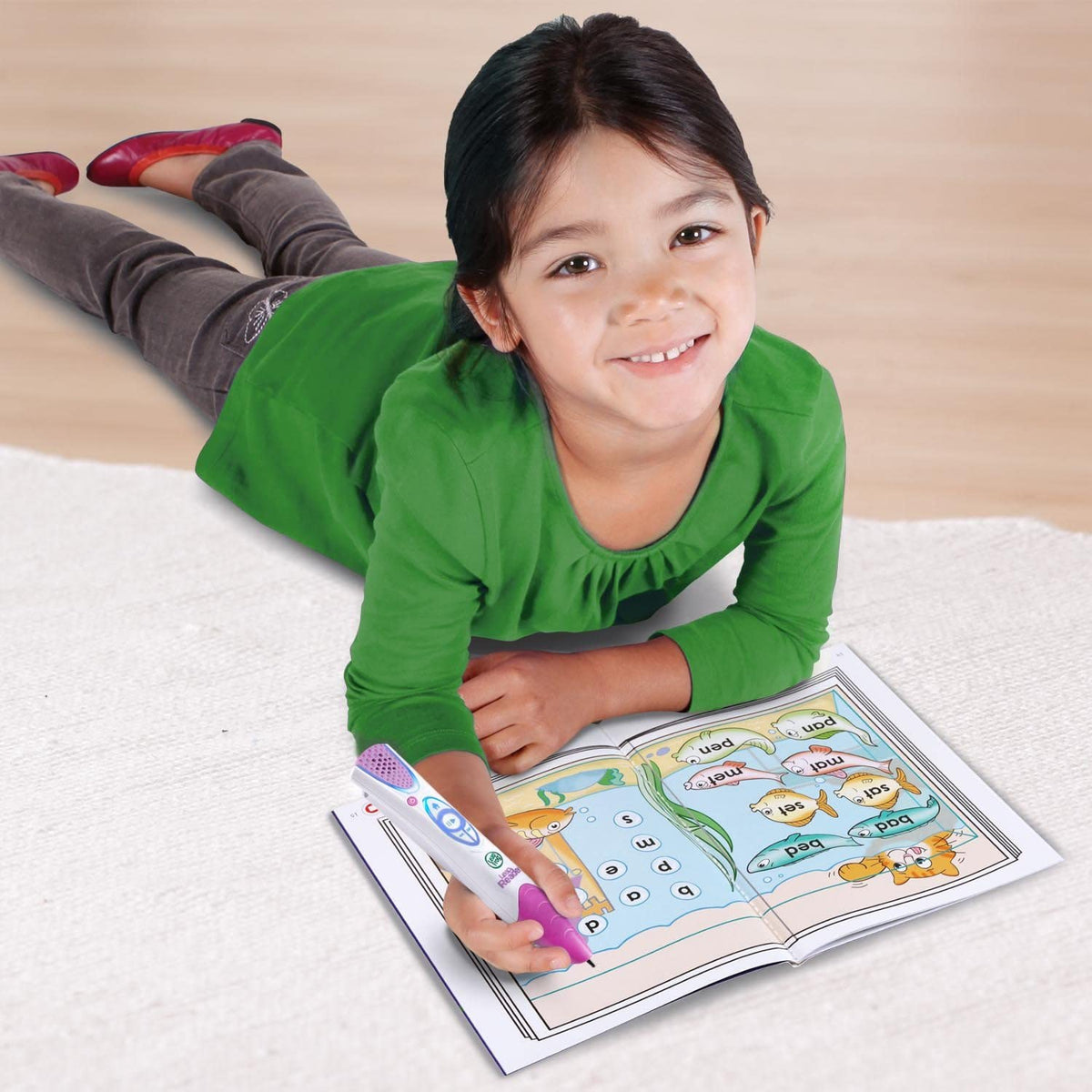 Child using a purple-and-white reading pen on an open LeapFrog workbook