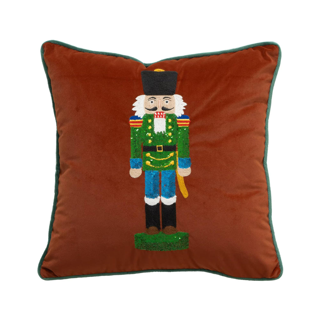 Brown velvet square pillow cover with full nutcracker embroidery and dark green edge piping.