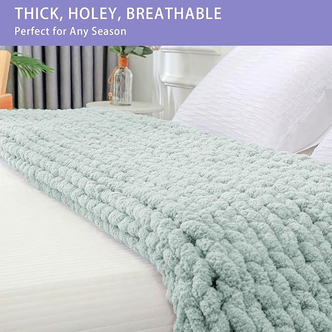 Mint chunky knit throw blanket with thick cable pattern laid across a bed edge