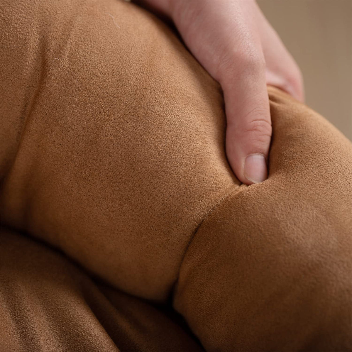 Brown round dog bed cushion, close-up of soft fabric surface.