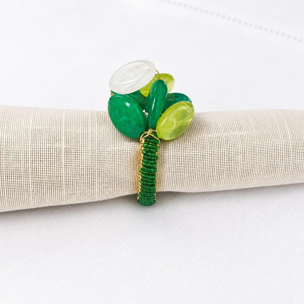 Green gemstone beaded napkin ring with white and yellow oval stones on gold band