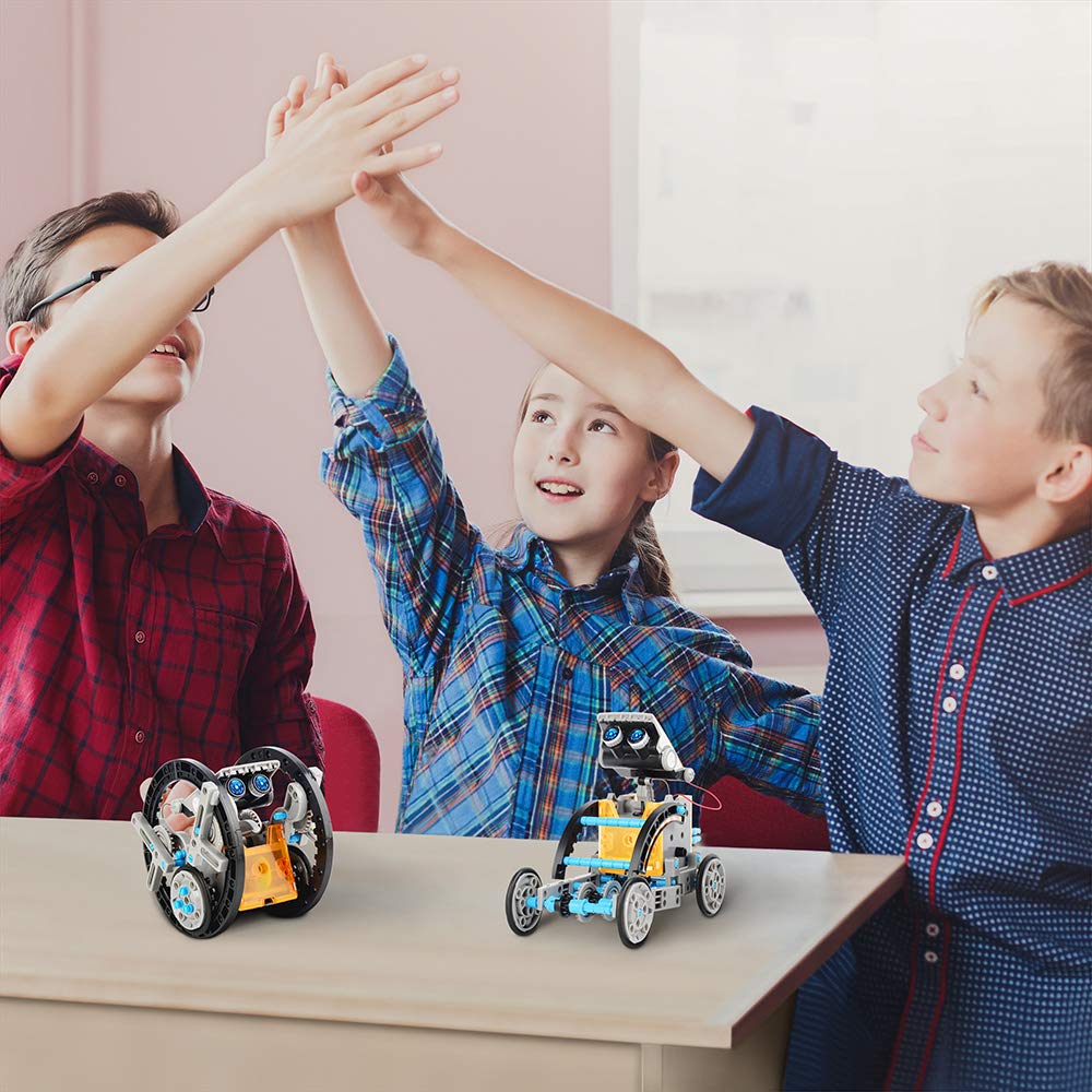Children holding and playing with solar-powered robot kit models on a tabletop