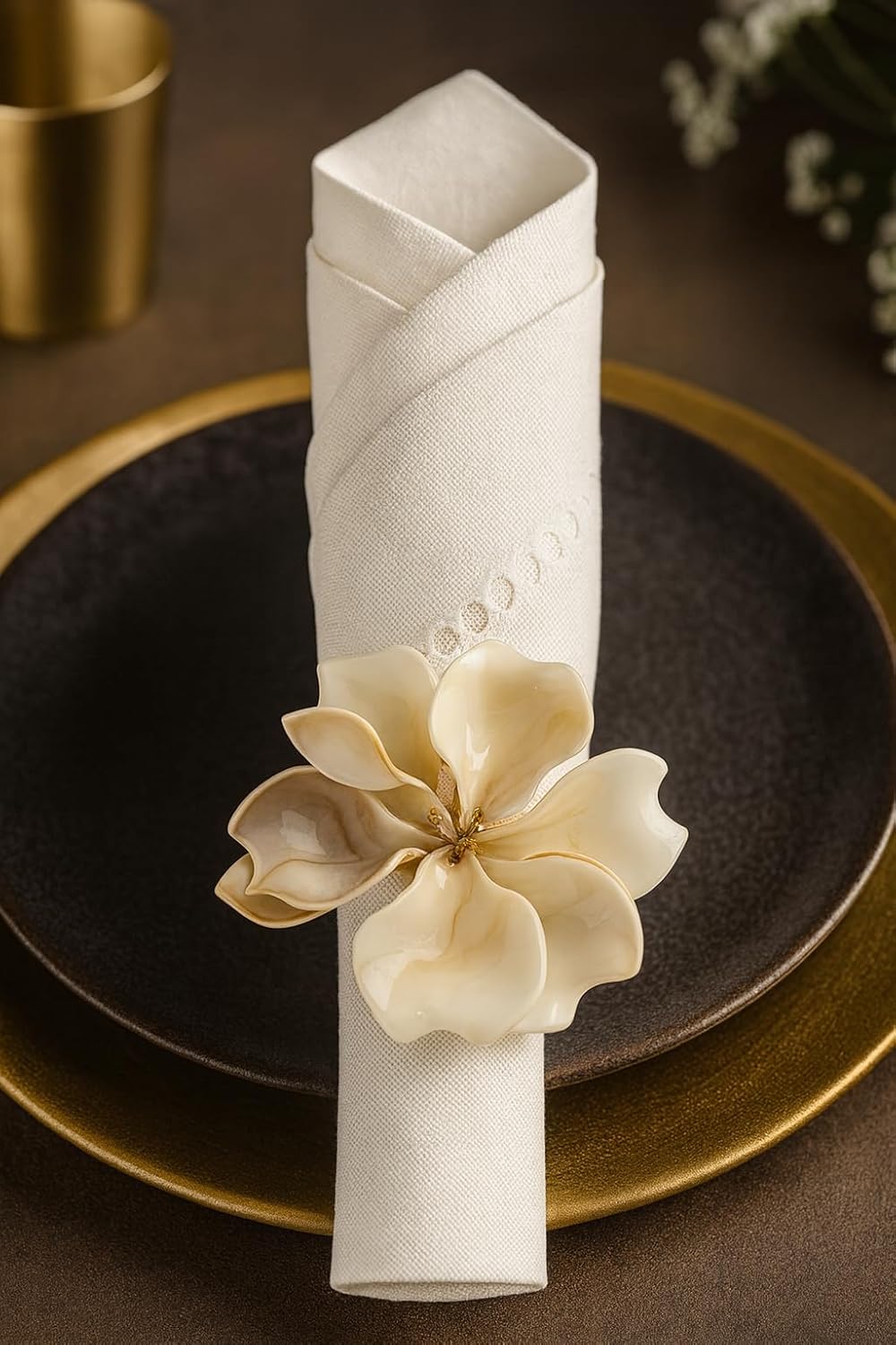 Decorative napkin ring with cream floral flower on a white fabric-wrapped holder