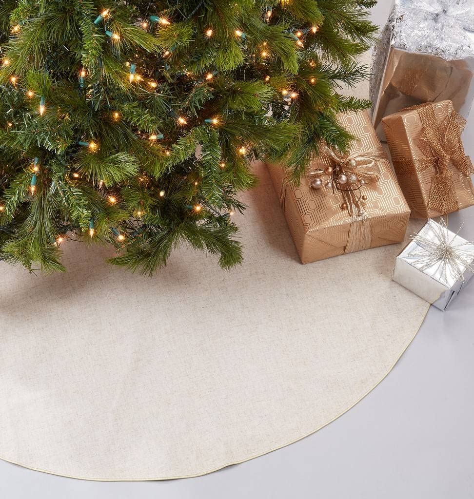 Natural round Christmas tree skirt, edge visible beneath tree and wrapped presents