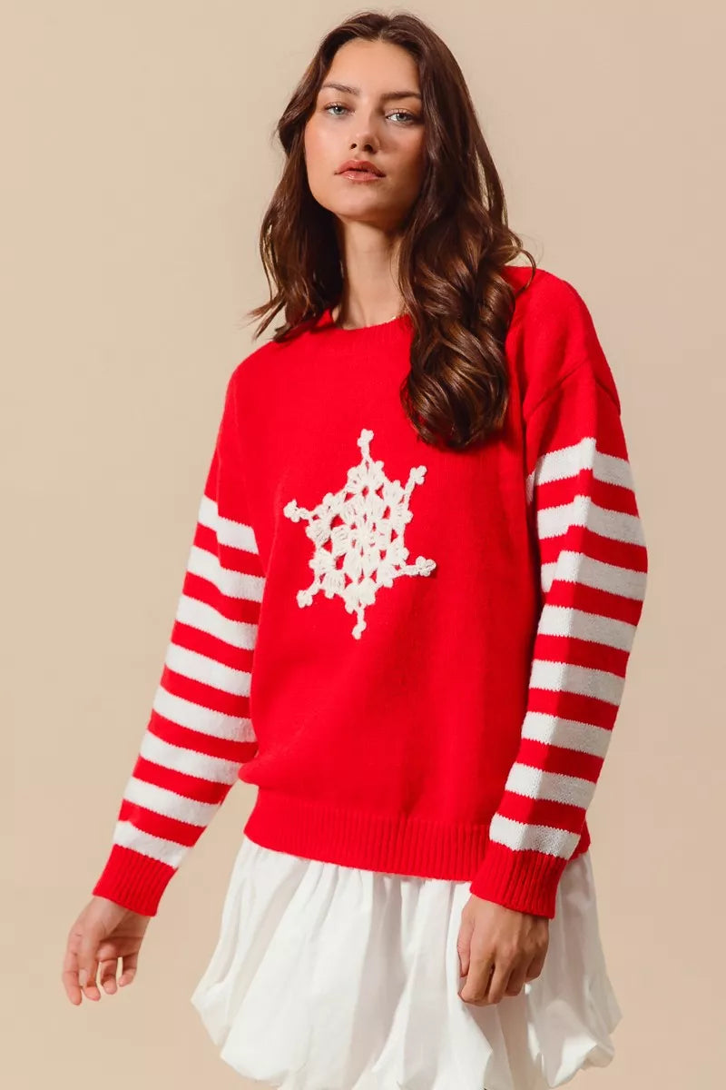 Red sweater with white crochet snowflake design and red-and-ivory striped sleeves