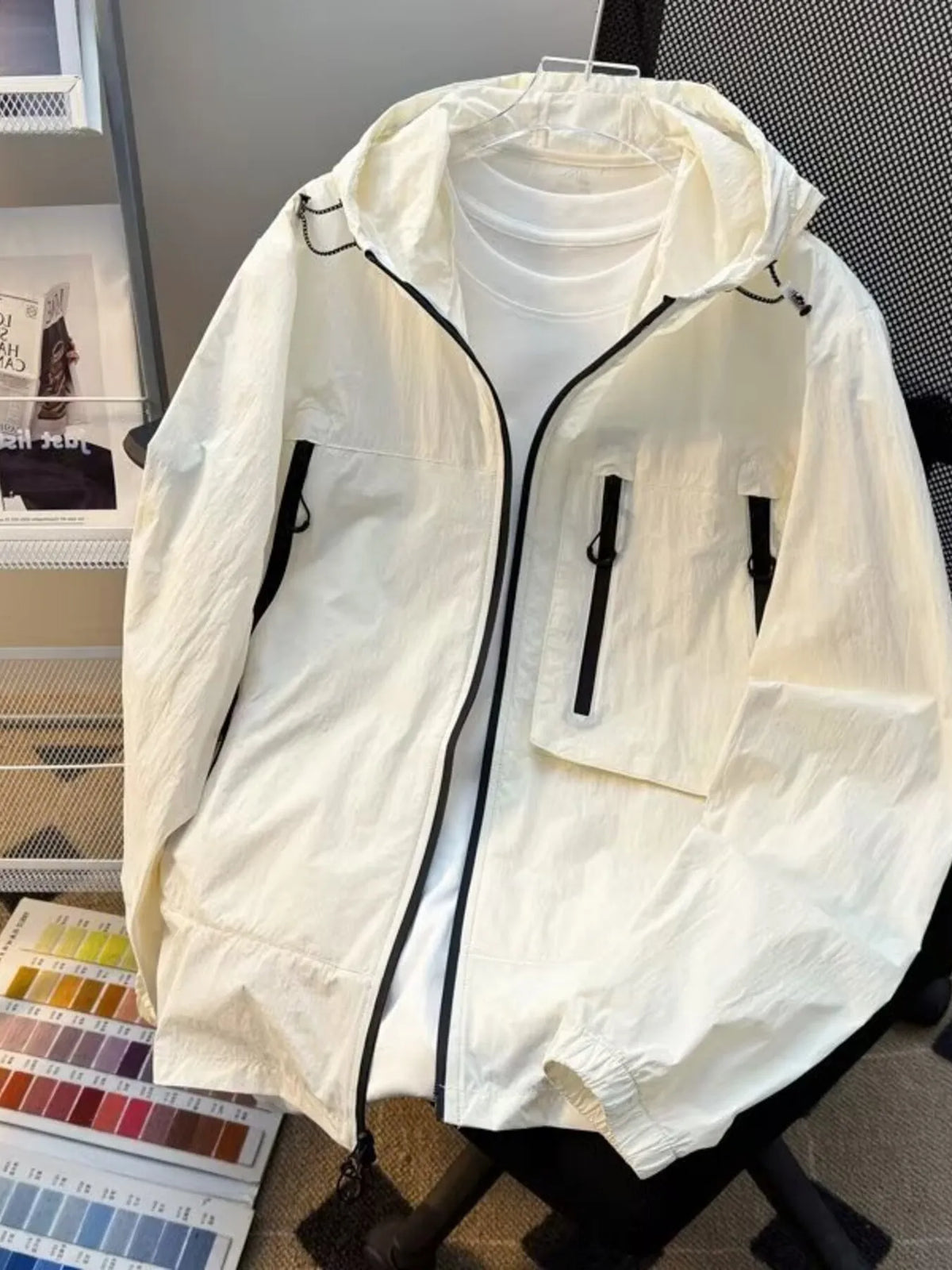 Lightweight hooded windbreaker jacket in off-white with front zip and utility pockets