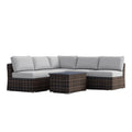 Dark gray wicker sectional sofa with white cushions and matching coffee table