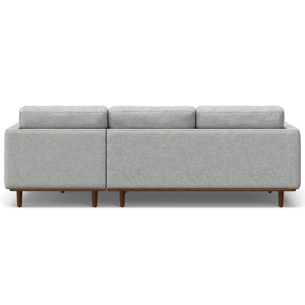 Upholstered sectional sofa in light gray fabric with boxed back and exposed wooden legs