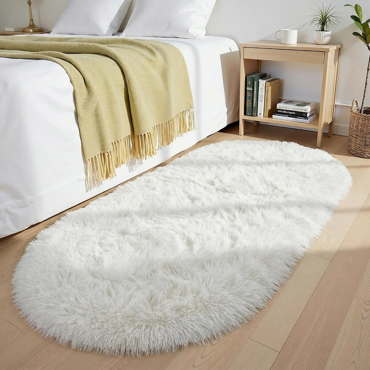 Ivory fluffy oval shag rug with thick long pile beside bed
