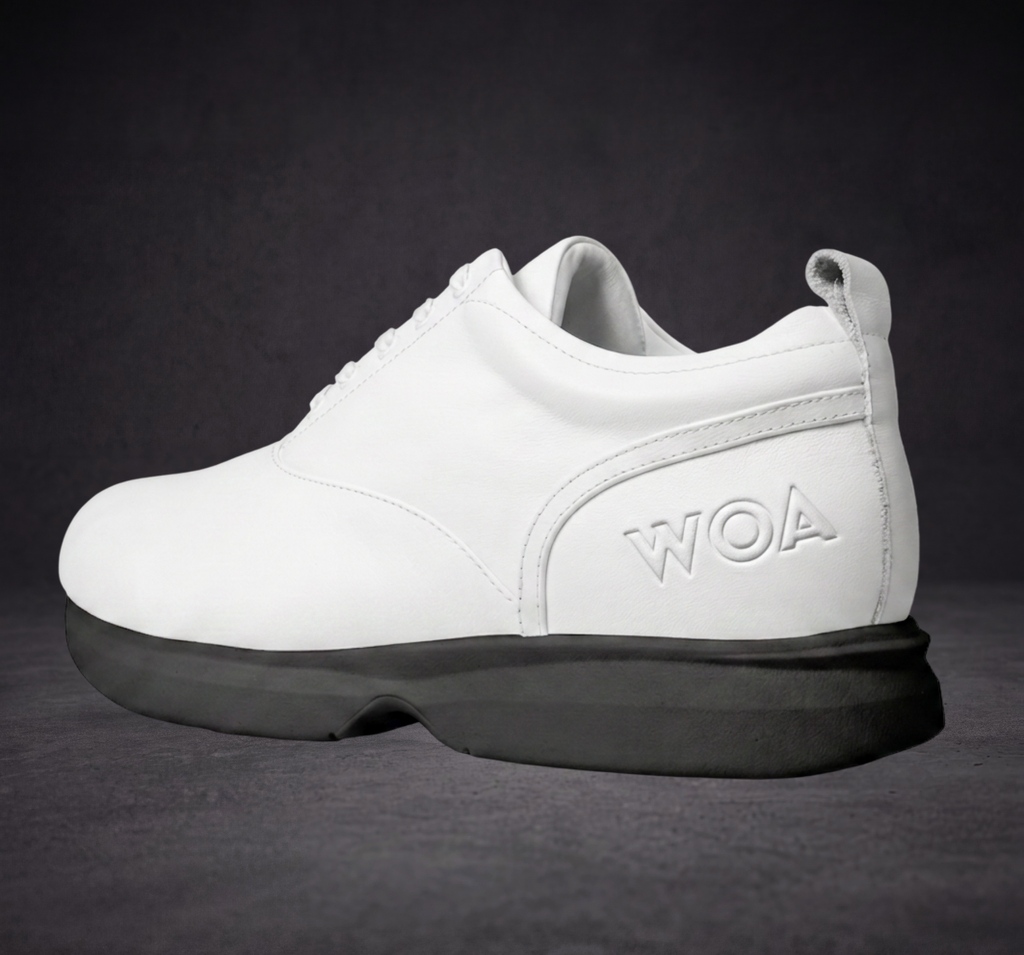 White lace-up sneaker with WOA logo on side, black sole and cushioned heel