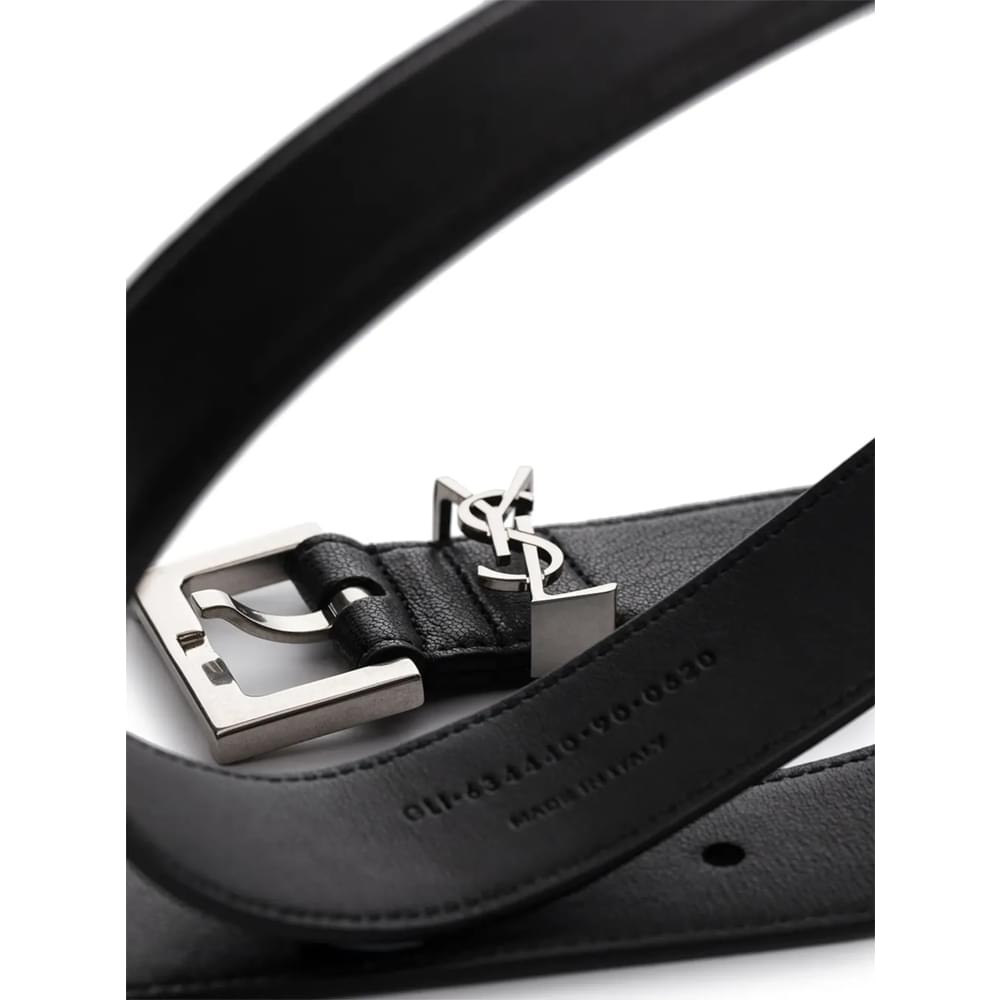 Black leather belt buckle close-up with Saint Laurent monogram and keeper strap