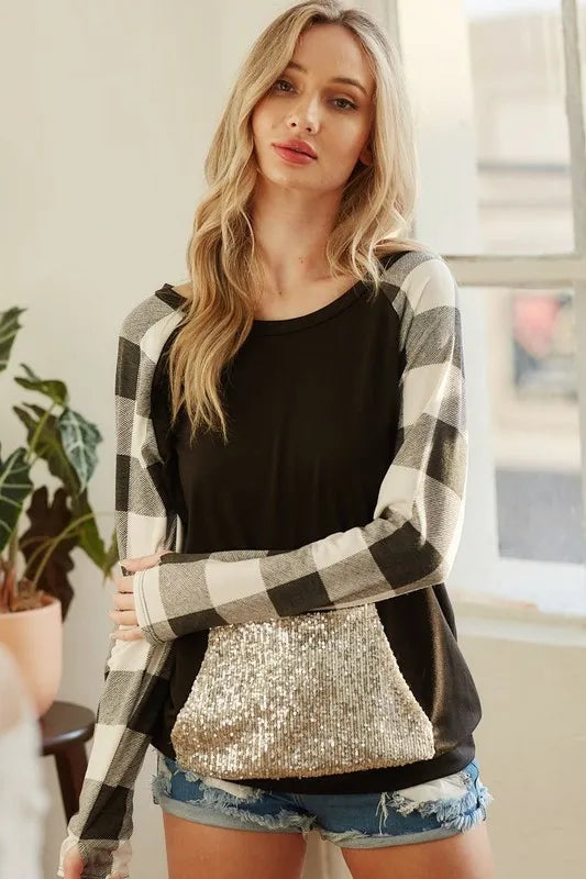 Black French terry top with black-and-gray check sleeves and gold sequin pocket detail