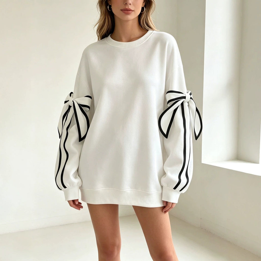 White crewneck long-sleeve sweater with black striped bow cuffs on both sleeves.