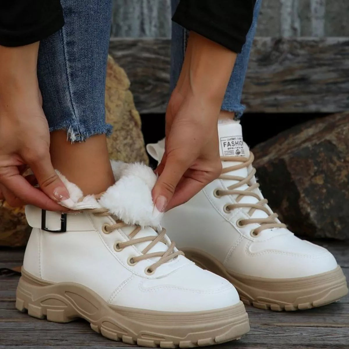 Pair of white warm-lined ankle boots with lace-up ties and buckle strap