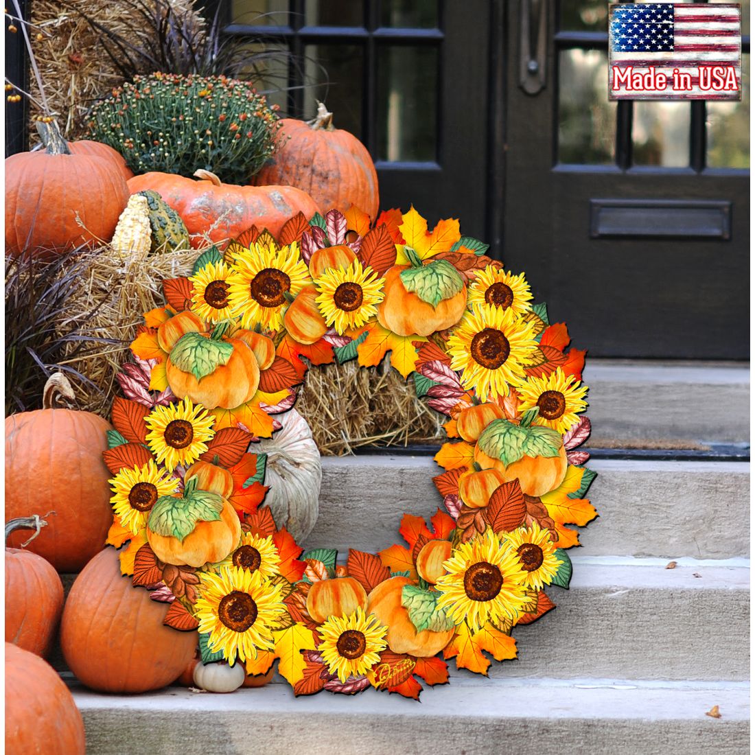 Orange pumpkin and sunflower autumn wreath on a hay bale display