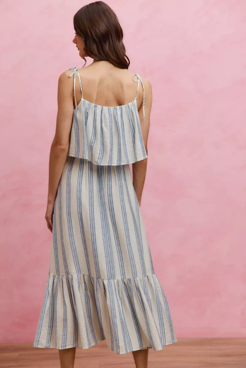 Back view of blue-and-white striped tiered midi dress with tie-back straps and tiered hem