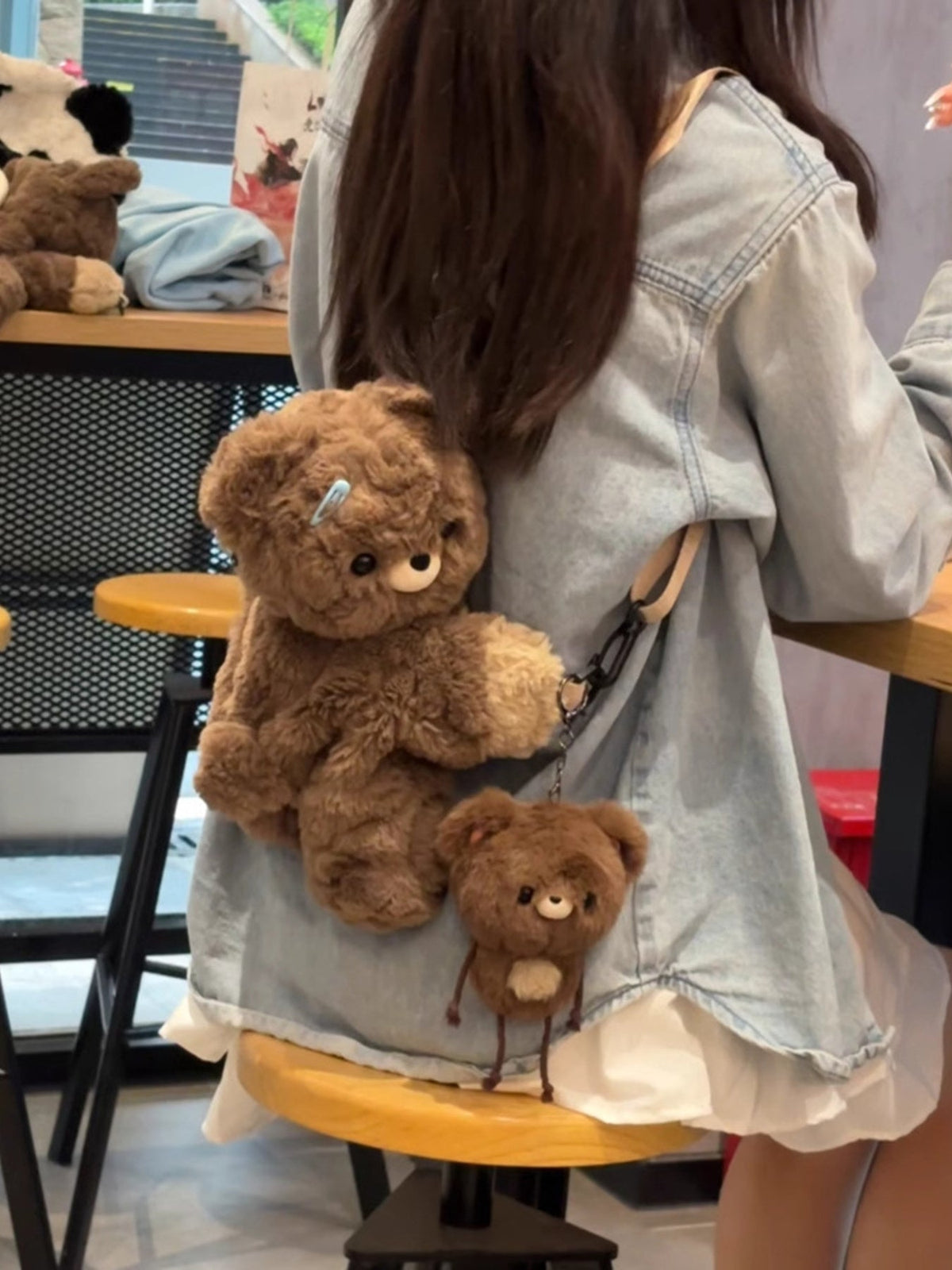Brown plush teddy bear backpack bag with front teddy plush and small bear charm on strap