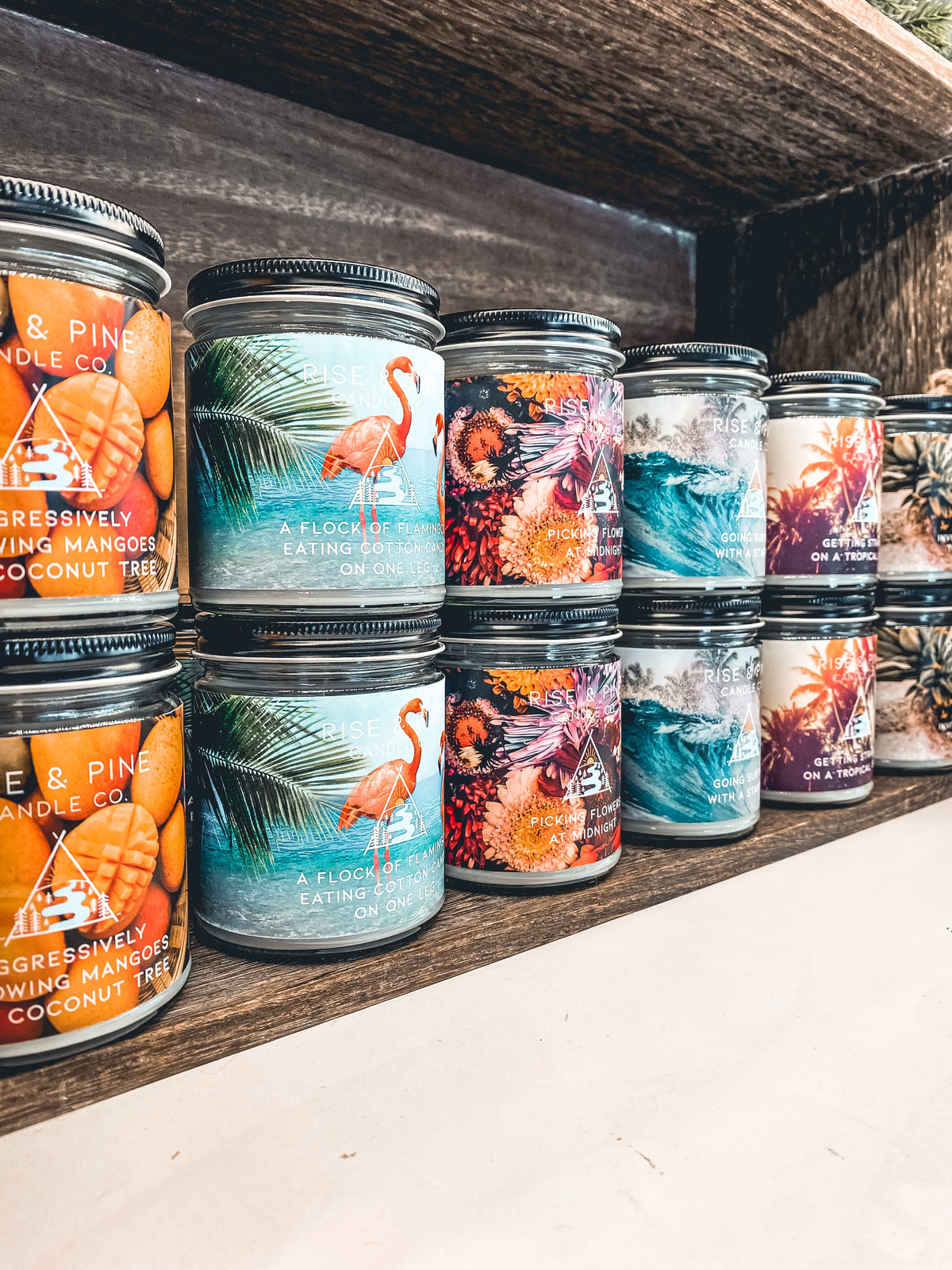 Set of soy wax candles in clear glass jars, assorted labels on display
