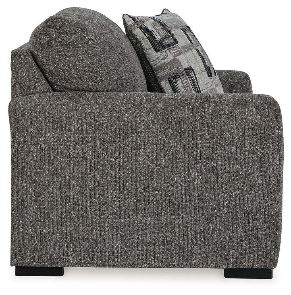 Pewter upholstered chair and a half with patterned throw pillow on the backrest