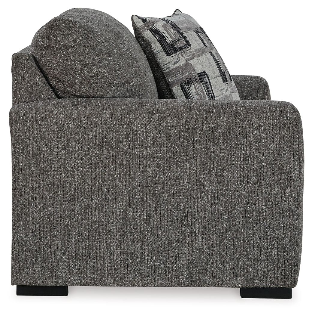 Pewter upholstered chair and a half with patterned throw pillow on the backrest