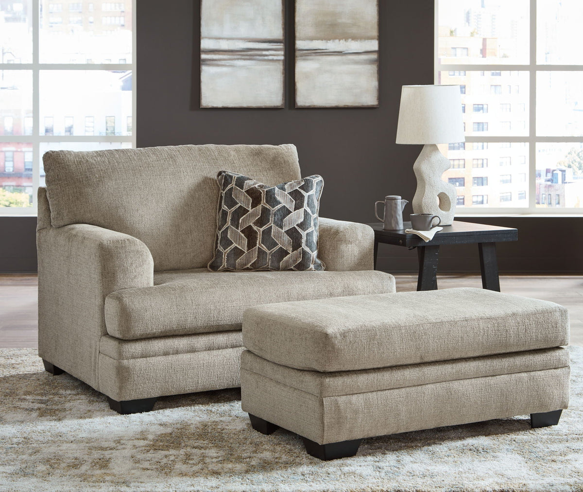 Light brown fabric sofa with geometric accent pillows and matching ottoman