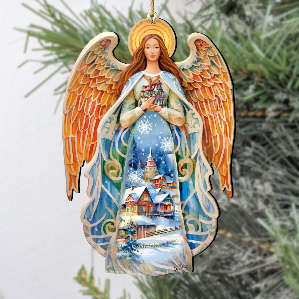 Wooden angel Christmas ornament on evergreen branches, blue dress and orange wings