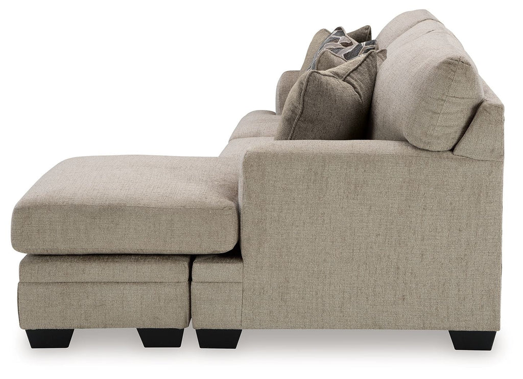 Upholstered loveseat with chaise-style profile, light gray-brown fabric and dark feet