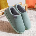 Green corduroy slip-on slippers with gray fuzzy lining and textured knit upper.