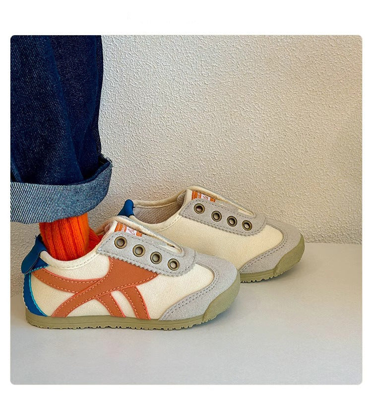 Kids casual sneakers with white uppers and orange side stripes, paired with beige sneakers.