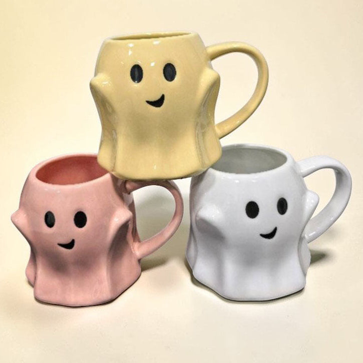 Ghost-shaped ceramic mug set showing yellow, pink, and white mugs
