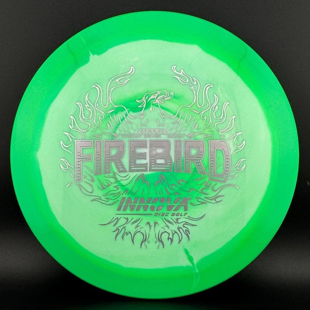 Disc golf driver with bright green face and dark fiery “Firebird” graphic